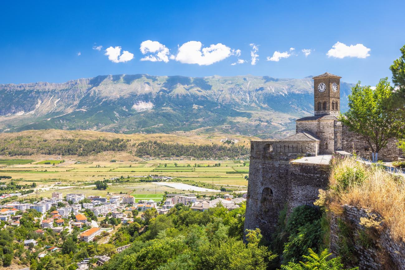 Gjirokaster fortress with a view of the valley and mountains and houses. Blue skies and a sunny day